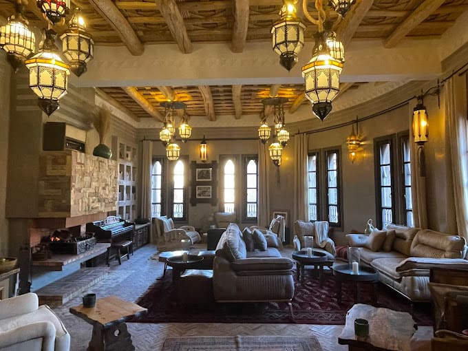 Elegant lounge of a boutique hotel in the Dades Valley with sofas, lanterns and tall arched windows